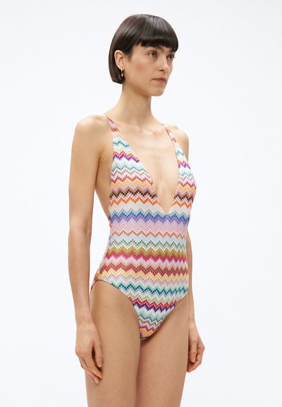 Kostium kąpielowy w wielokolorowy wzór zygzakowy, z głębokim dekoltem w kształcie litery V i szerokimi ramiączkami, wykonany z elastycznego materiału, odpowiedni do pływania.