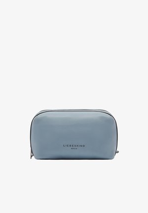 Miękka, niebieska skórzana kosmetyczka o zaokrąglonym kształcie, z zamknięciem na zamek oraz subtelnym logo z przodu. Gładka faktura i minimalistyczny design.