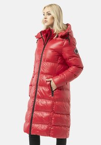 Roter Stepp-Puffer-Mantel mit Kapuze, gesteppter Textur, Frontreißverschluss und Seitentaschen. Mit schwarzen Akzenten und einem Logopatch am Ärmel.