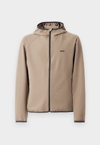 Beige gewatteerde jas met een ritssluiting aan de voorkant, zwarte accenten en een logo op de borst. Gemaakt van een gladde, rekbare stof met een getailleerd ontwerp.