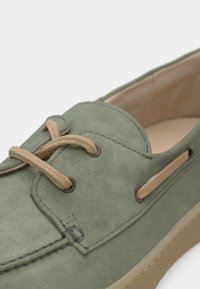 Πράσινο σουέτ παπούτσι τύπου boat με ταμπά κορδόνια, στρογγυλή μύτη και ραμμένες λεπτομέρειες. Διαθέτει δερμάτινες λεπτομέρειες και υφασμένη λαστιχένια σόλα.