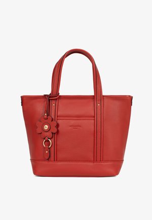 Borsa a mano in pelle rossa con doppi manici, tasca frontale e ciondolo portachiavi in pelle a forma di fiore attaccato al manico.