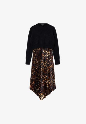 Maglione corto nero con una texture morbida, abbinato a una gonna midi plissettata con un motivo astratto arancione e marrone su uno sfondo nero.