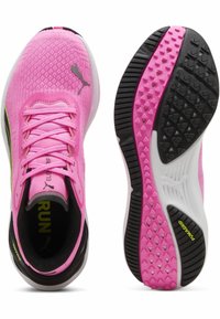 Roze gebreide hardloopschoenen met vetersluiting, zwart-witte zool, gestructureerde buitenzool en Puma-branding aan de zijkant en op de tong.