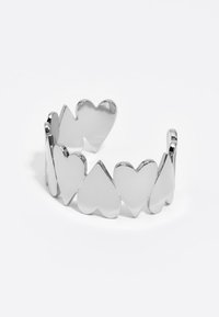 Pulsera de plata con corazones entrelazados con un acabado pulido, variando en tamaño, creando un diseño de pulsera abierta.