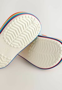 Balti gumijas zolīši ar zivju kaula rakstu, malu rotā krāsainas svītras sarkanā, zilā un dzeltenā krāsā.