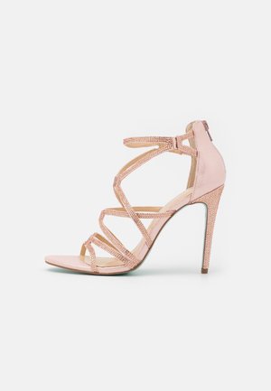 Sandale à talon haut à lanières en satin rose doré avec accents en strass, design à bout ouvert et talon aiguille élancé. Dotée d'une fermeture éclair à l'arrière.