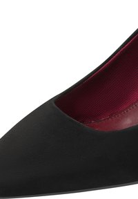 Chaussure plate en daim noir à bout pointu, avec une doublure intérieure côtelée rouge foncé et des finitions en cuir.