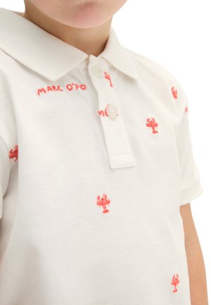 Kind trägt weißes Poloshirt mit kleiner roter Hummer-Stickerei und dem Schriftzug „Marc O'Polo“ nahe am Kragen.