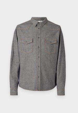 Grijze denimshirt met lange mouwen, puntige kraag en dubbele borstzakken. Heeft oranje stiksels en een knoopsluiting aan de voorkant.