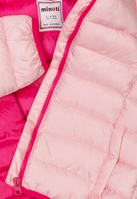 Giacca a vento rosa con un tessuto leggero e lucido, caratterizzata da un design trapuntato. Chiusura frontale con zip e etichetta che indica la taglia 4-5 anni.