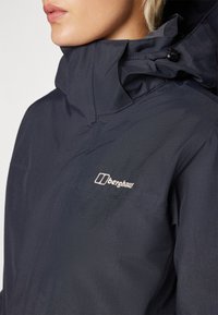Navy waterproof jacket with high collar, featuring adjustable hood, smooth texture, and embroidered logo on the chest.