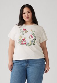 Short-sleeve, cream T-shirt featuring colorful floral and butterfly embroidery. Designed with a relaxed fit and round neckline.