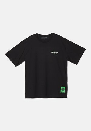 Schwarzes T-Shirt mit kurzen Ärmeln, kleinem "LES BENJAMINS" Logo auf der linken Brust und grünem rechteckigem Grafikdruck nahe dem unteren Saum.