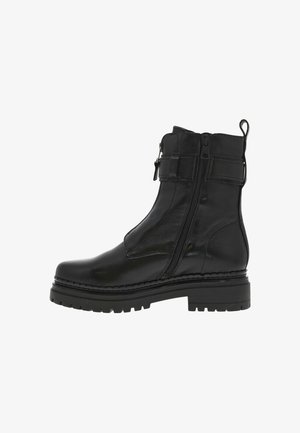 Bottines noires avec une finition en cuir lisse et brillant, des doubles zips et une semelle à crampons épaisse. Présente un accent cousu sur la semelle.