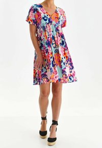 Värikäs kukallinen mekko, jossa on V-pääntie, löysä malli, lyhyet hihat ja kerrostettu muotoilu. Valmistettu kevyestä kankaasta, jossa on leikkisä kuvio.