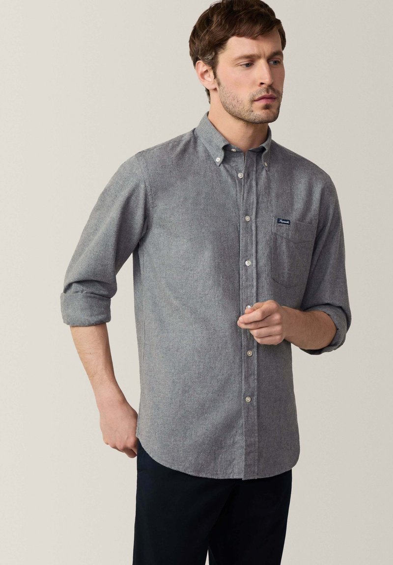 Grijze overhemd met een gemêleerde textuur, opgerolde mouwen en een borstzak; bevat een klein logo op de zak.