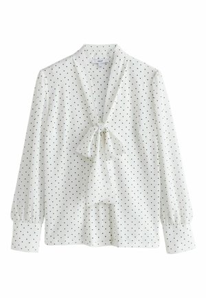 White blouse with black polka dots, long puffed sleeves, and a bow tie at the neck. Lightweight fabric, smooth texture, casual design.