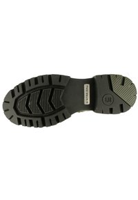 Zwarte rubberen schoenzool met diepe loopvlakken en een patroonontwerp. Voorzien van een gebosselde "G-STAR RAW" logo aan de zijkant.