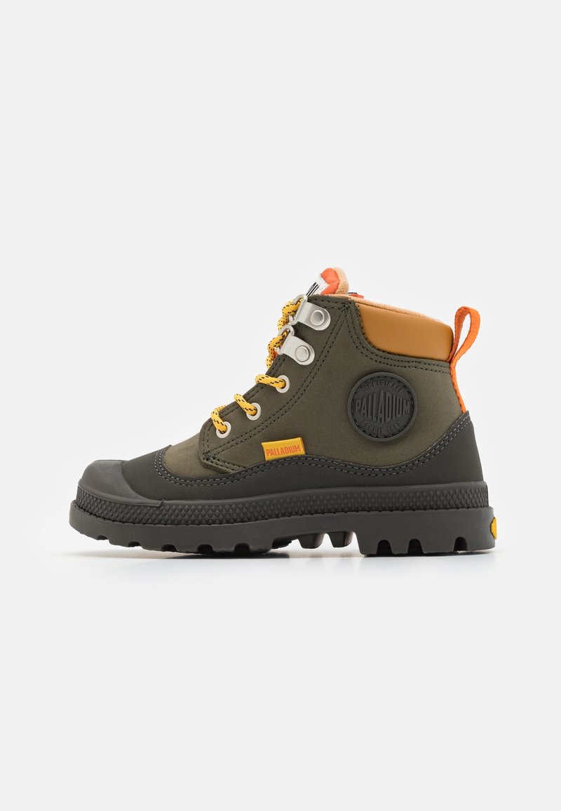 Botte montante robuste en tissu vert olive, semelle en caoutchouc noire, lacets jaune moutarde, languette orange, avec marquage sur le côté et le col du talon.