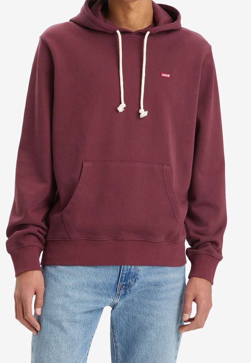 Vínový mikina s klokaní kapsou a šňůrkami. Obsahuje malé červené logo na hrudi. Měkký materiál, žebrované manžety a lem.