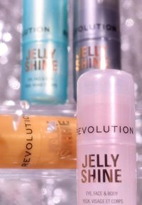 Klare rør med Jelly Shine fra Revolution i nyanser av lys blå, sølv og gul, med skinnende etiketter og ulike korkfarger.