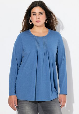 Haut bleu à manches longues avec un col rond, présentant des détails plissés au niveau de la poitrine. Tissu doux et silhouette décontractée.