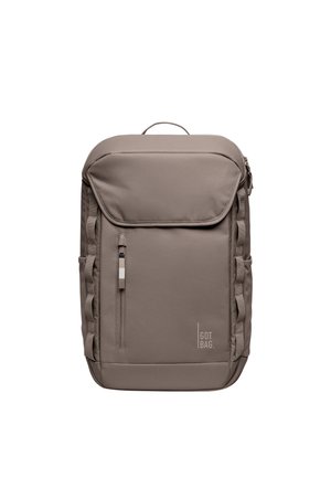 Rektangulær taupe rygsæk med øverste håndtag, frontlomme med lynlås, sideløkker og "GOT BAG" logo i nederste højre hjørne.