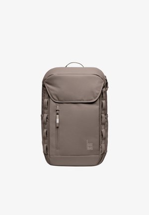 Prostokątny taupe plecak z górnym uchwytem, przednią kieszenią na suwak, bocznymi pętlami i logo "GOT BAG" w dolnym prawym rogu.
