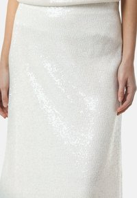 Weiße, mit Pailletten besetzte Midikostüm mit einer glatten, strukturierten Oberfläche und subtilen Glitzereffekten, figurbetonter Silhouette und rohem Saumdetail.
