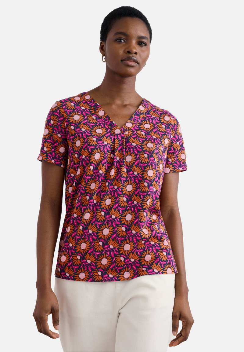 Bluză cu mânecă scurtă, florală, având decolteu în V, cu modele vibrante de portocaliu și roz pe un fundal închis, fabricată dintr-un material ușor.