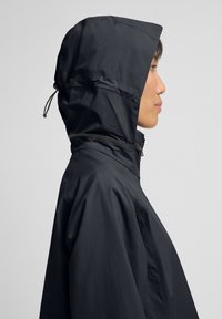 Wasserfeste schwarze Jacke mit passender Kapuze, Reißverschluss vorne und verstellbarem Kordelzug. Glattes Material mit einem eleganten, minimalistischen Design.