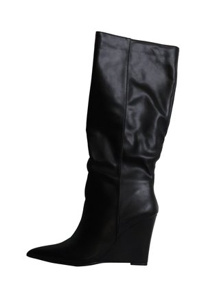 Botte mi-mollet en cuir noir avec bout pointu et talon compensé, texture légèrement froissée sur la tige.