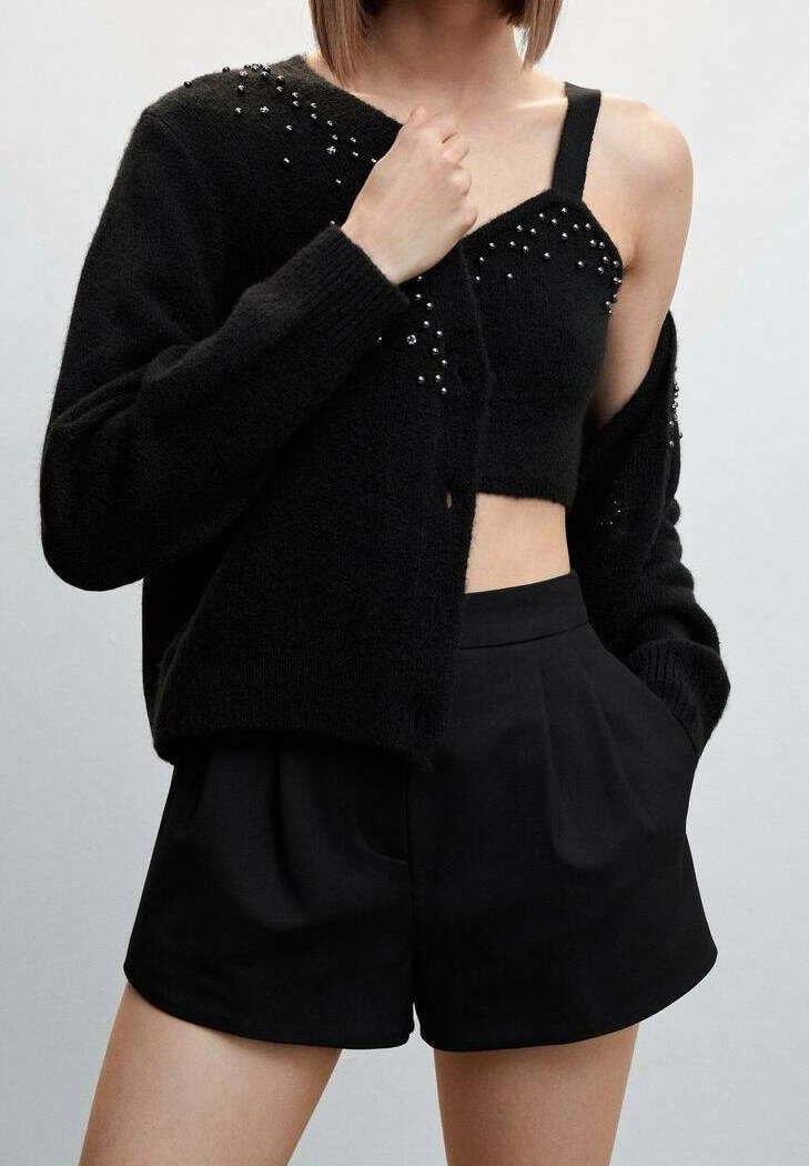 Black cardigan with sparkly accents, worn over a black cropped top and high-waisted black shorts, featuring a soft texture and relaxed fit.