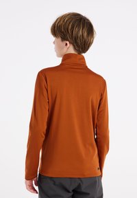 Langsleevige, oranje turtleneck van een soepele, rekbare stof, met een hoge kraag en een strak ontwerp zonder zichtbare logo's of patronen.