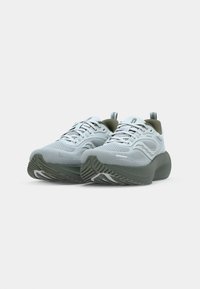 Baskets en mesh bleu clair avec des accents vert olive, surface texturée, semelles épaisses grises, et détails contrastants en noir et blanc sur les lacets.