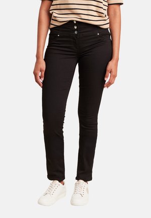 Zwarte skinny jeans met een hoge taille en een vijf-pocket ontwerp. Gecombineerd met een gestreept T-shirt met korte mouwen en witte sneakers.