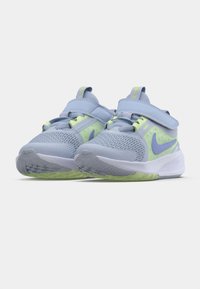 Světle modré sportovní boty s síťovinovými svrchními částmi, neonově zelenými akcenty, suchými zipy a bílými gumovými podrážkami s texturovaným vzorem.