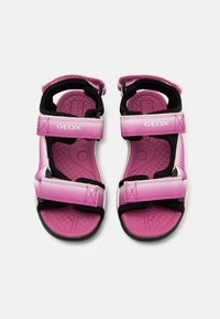 Pink Geox sandals featuring synthetic straps, black accents, adjustable Velcro closures, and textured inner soles for grip.
