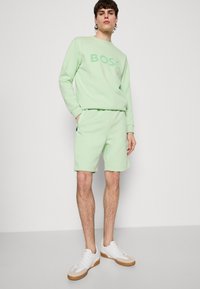 BOSS HEADLO - Spodnji deli trenirk - open green