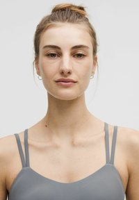 Grijze cami met dunne bandjes, gladde textuur en een ronde halslijn. Eenvoudig ontwerp, geschikt voor layering of casual wear.