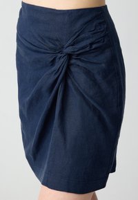 Marineblaue Leinenrock mit verdrehtem Vorderteil und gerafften Seiten, gerader Saum und weicher Textur.