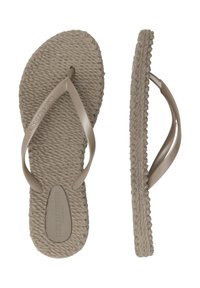 Chanclas beige con suelas texturizadas trenzadas, correas de plástico y acentos elevados. Presenta un logo en la suela. Diseño plano y casual.