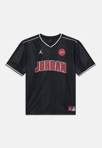 Black basketball jersey with red "JORDAN" text, white Jumpman logo, red circular patch, and white-striped collar and sleeve cuffs.