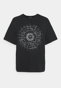 Camiseta de algodón negra que presenta un gráfico celestial blanco con un estallido de sol y constelaciones dispuestas en un patrón circular.