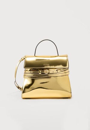 Borsa Moschino Milano in metallo dorato con manico superiore, dettaglio fibbia frontale e forma rettangolare strutturata su sfondo bianco.