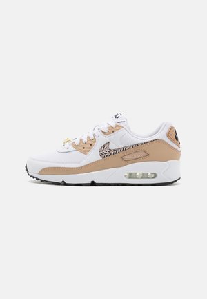 Biało-beżowe buty sportowe Nike Air Max z logo we wzory, widoczną podeszwą z poduszką powietrzną, białymi sznurowadłami i czarną podeszwą na jednolitym tle.