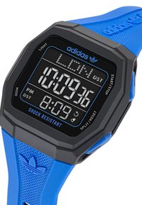Orologio sportivo digitale con quadrante nero, accenti blu e cassa resistente agli urti. Presenta un cinturino in gomma blu con motivo testurizzato.