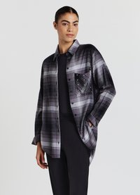 Camicia a quadri in tonalità di grigio, con taschino sul davanti decorato con borchie, maniche lunghe e vestibilità comoda. Tessuto morbido.