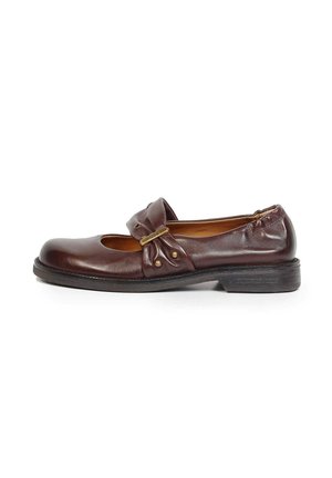 Chaussure Mary Jane en cuir marron foncé avec petit talon, bride latérale avec quincaillerie dorée et clous décoratifs, sur fond blanc.
